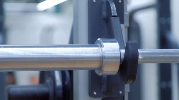 Womans hands is hanging disc load on a barbell in gym before doing exercise. — Stock Footage Womans hands is hanging disc load on a barbell in gym before doing exercise. Video Clip