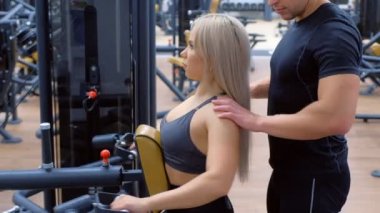 Sportif kadın kürek çekme makinesinde omurga kasları için egzersiz yapıyor..