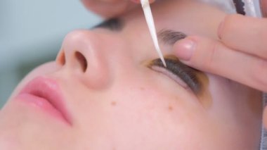 Kozmetikçi kirpikleri iğneyle bigudilere büker, kirpikleri kaldırır..
