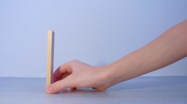 İnsanlar tahta blokları domino taşları gibi inşa eder ve birini iterek tahrip eder..