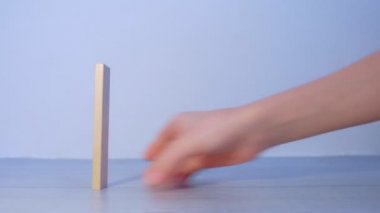 İnsanlar tahta blokları domino taşları gibi inşa eder ve birini iterek tahrip eder..