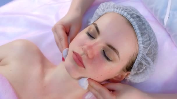 Estetista pulisce il collo e il viso delle donne con batuffoli di cotone in clinica di bellezza. — Video Stock