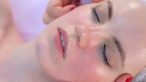 Medico cosmetologo che fa massaggio facciale mioplastico alla donna in clinica di bellezza. — Video Stock