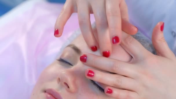 Kosmetolog läkare gör myoplastisk ansiktsmassage till kvinna på skönhetskliniken. — Stockvideo