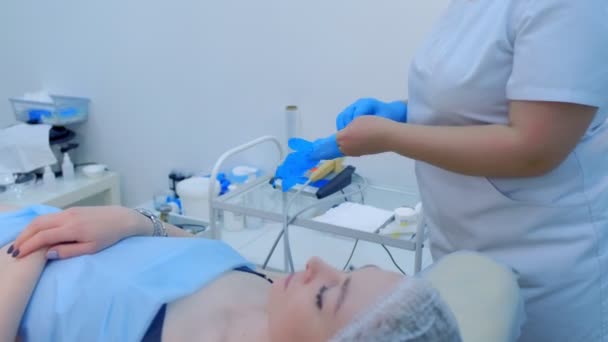 Косметолог надевает перчатки перед косметической процедурой в клинике красоты. — стоковое видео