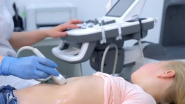 Doktor çocuk için tarama ve yan görüş kullanarak karın ultrasonu yapıyor..