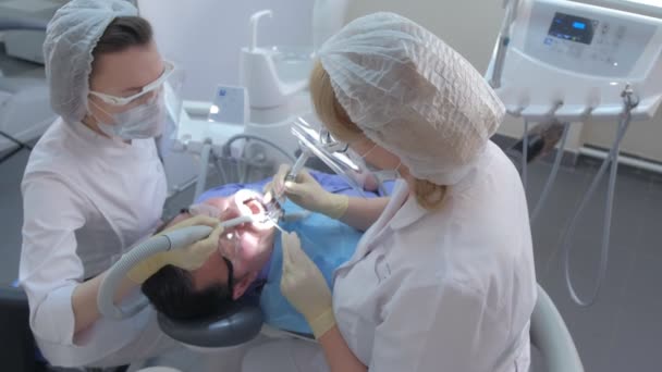 Paciente hombre en procedimiento de limpieza de dientes ultrasónicos en odontología por dentista. — Vídeo de stock