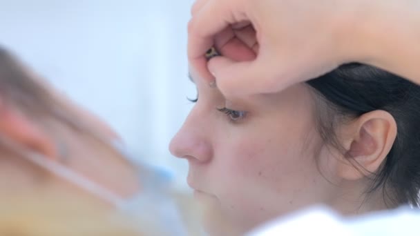 Cosmetologue peinture des sourcils pour la femme cliente avant la procédure de microblading. — Video