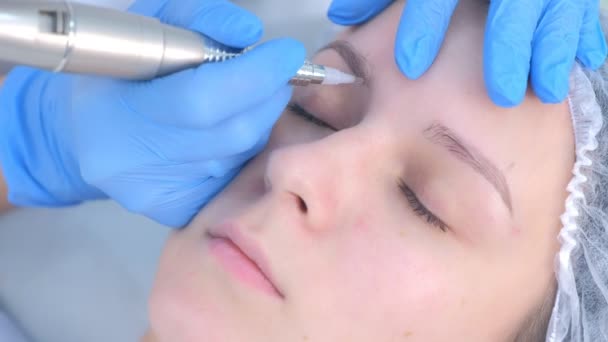 Cosmetologist fazendo sobrancelhas microblading procedimento no salão de beleza para menina. — Vídeo de Stock