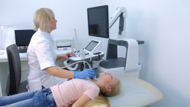 Médico examinando paciente menina glândula tireóide usando scanner de ultra-som. — Vídeo de Stock