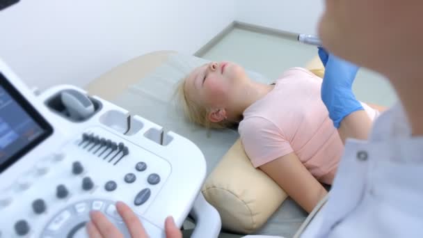 Lekarz badający pacjenta dziecko dziewczyna tarczycy za pomocą skanera ultrasonograficznego. — Wideo stockowe
