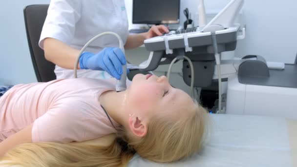 Orvos vizsgálata beteg gyermek lány pajzsmirigy segítségével ultrahang szkenner. — Stock videók