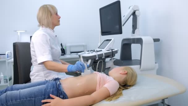 Orvos vizsgálata beteg gyermek lány pajzsmirigy segítségével ultrahang szkenner. — Stock videók