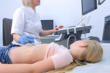 Doktor çocuk için tarama ve yan görüş kullanarak karın ultrasonu yapıyor..