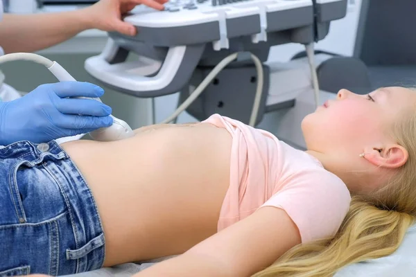 Doctor is making abdominal ultrasound for child girl using scanner, side view. — Stock Image Doctor is making abdominal ultrasound for child girl using scanner, side view. Royalty Free Stock Images