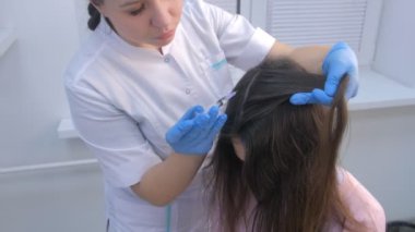 Doktor trikoloğum kadın tenine saç için mezoterapi yapıyor..