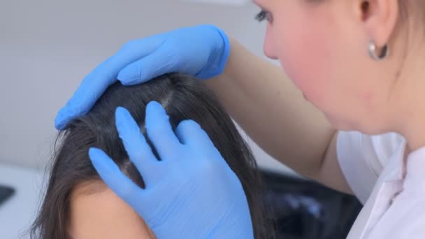 Lékař tricholog vyšetřuje ženy vlasy na klinice po konzultaci. — Stock video