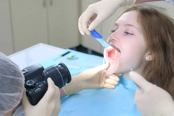 Zahnarzt Kieferorthopäde fotografiert mit Kamera Mädchenzähne zeigt es im Spiegel. — Stockfoto