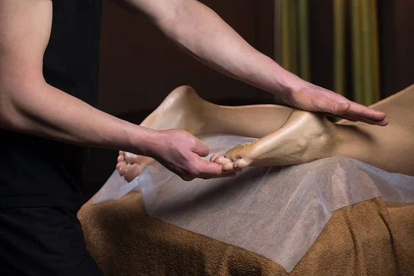 Massagist szorowanie stóp kobiet z naturalnym peeling w salonie spa obieranie ciała. — Zdjęcie stockowe