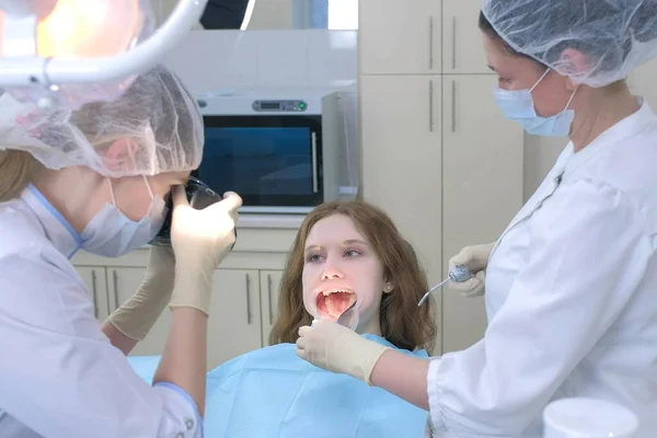 Dentist orthodontist photographing using camera girl teeth showing it in mirror. Stock Image