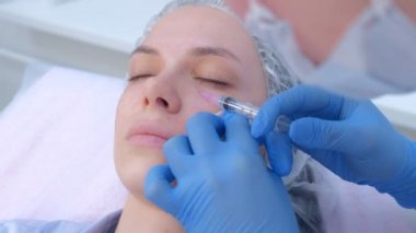 Güzellik uzmanı kadın derisine birden fazla enjeksiyon yapıyor..