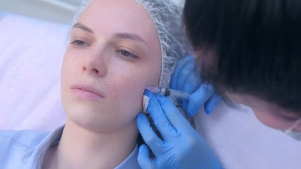 Косметолог, який робить декілька ін'єкцій біоревіталізації в шкірі обличчя жінки . — стокове відео