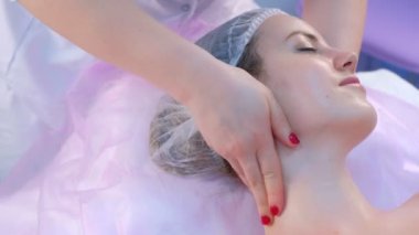 Masajcı doktor genç bir kadına miyoplastik boyun masajı yapıyor, yakın plan portre..