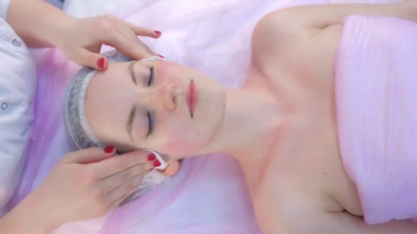 Esteticista limpa o pescoço e o rosto das mulheres após a massagem facial na clínica de beleza. — Vídeo de Stock