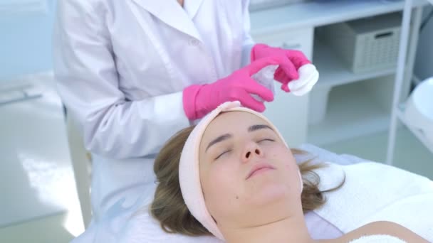 Kosmetici ruce peeling otírání ženy tvář bavlněné podložky v kosmetické klinice. — Stock video