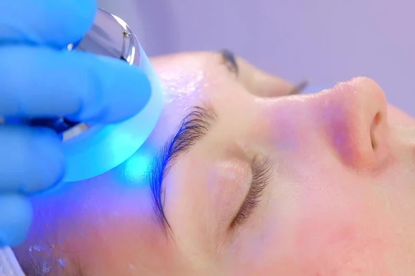 Cosmetologist doctor is making phonophoresis procedure on woman face, closeup. — Stock Photo, Image