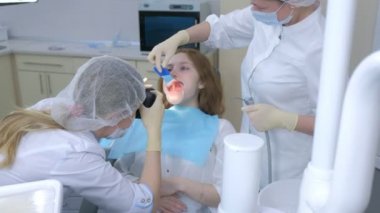 Dişçi ortodontist, kameraman kız dişlerini kullanarak bunu aynada gösteriyor..