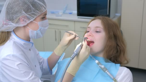 Dentiste femme nettoyage des filles dents à l'aide d'une brosse à dents électrique en dentisterie. — Video