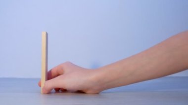 İnsanlar tahta blokları domino taşları gibi inşa eder ve birini iterek tahrip eder..