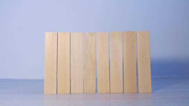 Man druppels houten blokken in rij als hek via een, hand close-up uitzicht. — Stockvideo