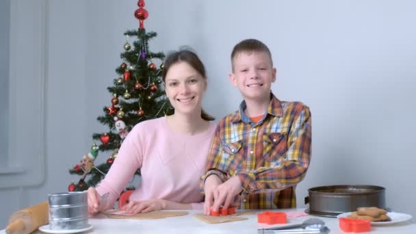 Moeder en zoon maken koken peperkoek koekjes lookind op camera en glimlachen. — Stockvideo