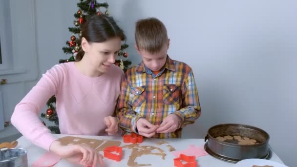 Maman et son fils font cuire des biscuits au pain d'épice ensemble à la maison. — Video