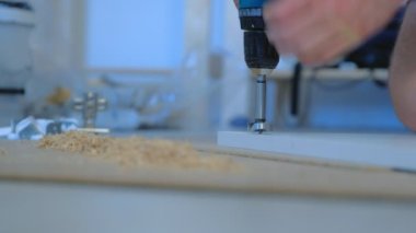 Adam yonga tahtasına yuvarlak bir delik açıyor ve gardırop kapısı yapıyor..