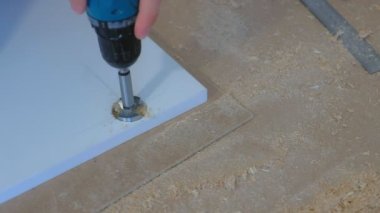 Kapı menteşeleri için adam yuvarlak delik yonga kullanıcı elektrikli matkap, yakın çekim.