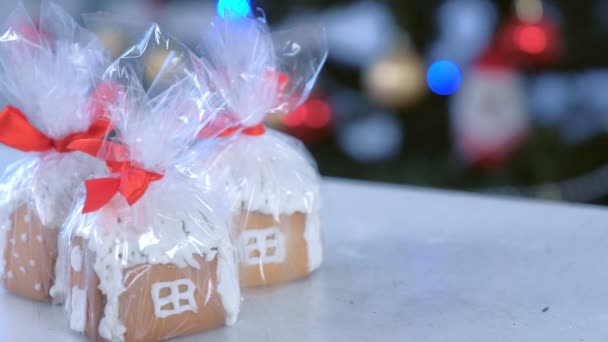 Пряникові будиночки в пакеті як подарунки на Різдво на фоні дерева . — стокове відео