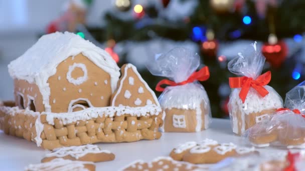 Lebkuchenhäuser und Plätzchen im Paket für Weihnachten auf Baumhintergrund. — Stockvideo