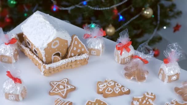 Casas de pan de jengibre y galletas en paquete para Navidad en el fondo del árbol. — Vídeos de Stock