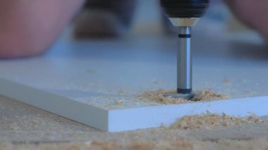 Marangoz kapı menteşeleri için yuvarlak delikler açıyor..