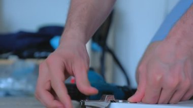 Marangoz elektrikli tornavida kullanarak mobilya kapısına menteşe yapıyor..