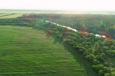 Nehir ve orman yakınlarındaki kırsal alanların üzerinde uçuyorlar..