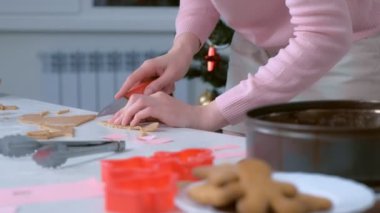 Zencefilli kurabiye evi için parça kesip tepsiye koyan kadın..