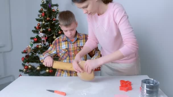 Mamá e hijo están haciendo masa de jengibre para galletas de Navidad juntos en casa. — Vídeos de Stock