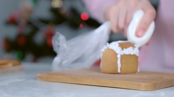 Жінка робить клей для імбирного будинку частинами з цукровою солодкою глазур'ю, крупним планом руки . — стокове відео