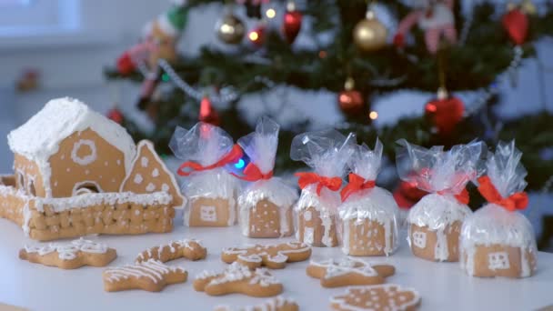 圣诞树背景下的姜饼屋和饼干包起来. — 图库视频影像