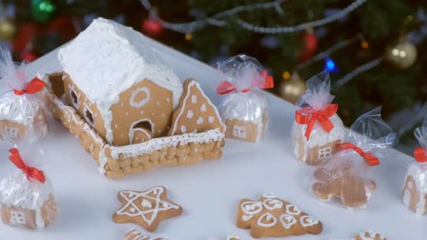 Lebkuchenhäuser und Plätzchen im Paket für Weihnachten auf Baumhintergrund. — Stockvideo