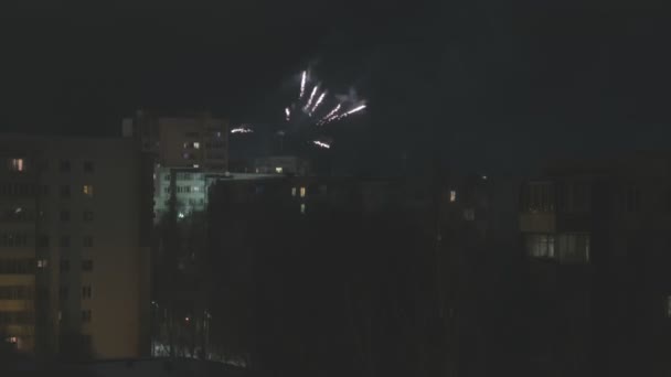 Fuochi d'artificio colorati in cielo scuro sopra edifici in città in vacanza di anno nuovo. — Video Stock